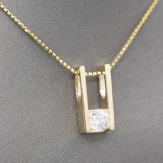 This brilliant sparkler is beautifully crafted and emanates richness. The pendant is rectangular and holds a round brilliant cut natural diamond at the base in a tension setting. The integral bail is large enough to accommodate a large chain or small omega, measuring about 6mm in width at the widest area. The pendant hangs on a thicker-than-normal box chain necklace with features a spring ring clasp. The result is a stunning simplicity, looking equally elegant in casual and dress ensembles. The Tension Setting, Flower Jewelry, Diamond Pendant Necklace, Flower Jewellery, Box Chain, Spring Rings, Diamond Pendant, Round Brilliant, Natural Diamonds