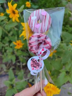 a person holding up some candy in front of sunflowers and yellow flowers with the words happy birthday written on them