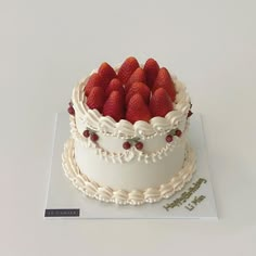 a white cake topped with strawberries on top of a table