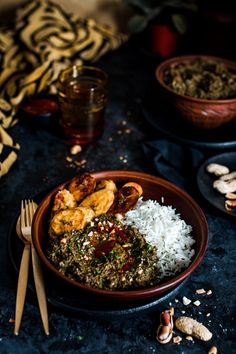 a bowl filled with rice and shrimp on top of a table