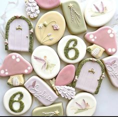 decorated cookies are arranged in the shape of numbers and fairy door decorations on a marble surface