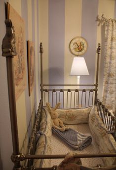 a baby crib in the corner of a room with a lamp on top of it