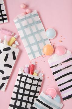 some candy bags are laying on a pink surface