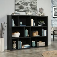 a black bookcase filled with lots of books on top of a hard wood floor