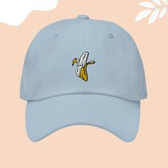 Go bananas for this embroidered hat featuring a fun and fruity banana design! 🍌🧢 It's time to embrace the quirky side of fashion and let your personality shine through! 🌟

So why slip up on this opportunity to add a touch of tropical flair to your wardrobe? #BananaHat #FruityFashion #EmbroideredHat #StandOut #FashionFun #TropicalVibes #StyleStatement #BananaLove #Accessories #QuirkyFashion #etsystore #etsyseller #etsyshop #handmade #etsyfinds Novelty Dad Hat Snapback Adjustable, Casual Blue Embroidered Dad Hat, Embroidered Blue Dad Hat Adjustable, Blue Embroidered Cotton Dad Hat, Embroidered Dad Baseball Cap, Peeled Banana, Banana Design, Go Bananas, Trendy Fits