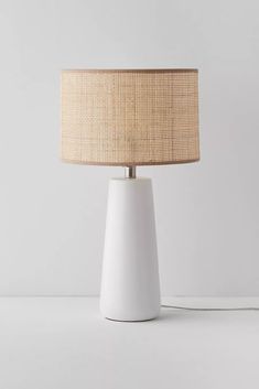 a white table lamp with a beige shade