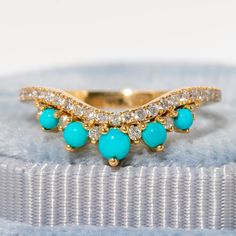 a gold ring with turquoise stones and diamonds