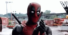 the deadpool is holding two knives in his hands