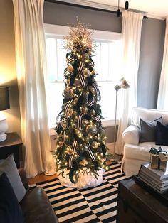 a living room with a christmas tree and black and white striped rug on the floor