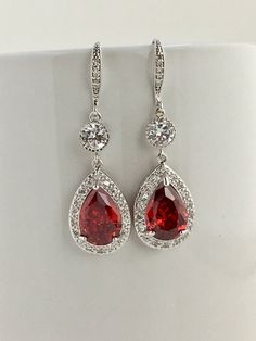 I've created this gorgeous luxury red ruby cubic zirconia bridal tear drop earrings in rhodium plated brass setting. Earrings feature a large teardrop with pear cut red ruby cubic zirconia center surrounded by tiny round zirconia crystals. Teardrop dangles from a round cubic zirconia connector and zirconia detailed ear wire. Total length of the earrings is 5 cms. For matching necklace click: https://www.etsy.com/listing/481708432/red-ruby-cubic-zirconia-bridal-necklace?ref=shop_home_active_20 ht Earrings For Red Dress, Expensive Jewelry Luxury Red, Ruby Dangle Bridal Earrings, Ruby Dangle Bridal Earrings As Gift, Red Drop Bridal Earrings For Formal Occasions, Red And Silver Jewelry, Elegant Ruby Bridal Earrings For Anniversary, Elegant Wedding Jewelry With Lab-created Ruby, Elegant Lab-created Ruby Jewelry For Wedding