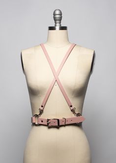 This harness belt is made in thick, strong, colorful PVC or leather. Criss-cross style shoulder straps are detachable and adjustable. Wear them criss-crossed in front, back, or both!. Buckles at front and shoulder straps. Fit is adjustable with buckles. Silver-toned nickel plated steel hardware on all colors.Shown in blush pink leather.Available in many leather and PVC colors. Neon Pink and Neon Orange PVC are UV/Blacklight reactive! All pieces are MADE TO ORDER, standard sizes XS-4XL. If your m Punk Harness With Adjustable Straps, Edgy Strapped Harness With Belt, Adjustable Strapped Harness With Belt, Adjustable Leather Harness With Belt, Adjustable Strapped Punk Harness, Leather Harness With Straps, Leather Harness With Adjustable Strap, Leather Strapped Harness With Belt, Edgy Adjustable Harness With Belt