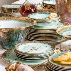 a table topped with lots of plates covered in gold and blue dishes next to each other