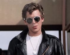 a man wearing sunglasses and a leather jacket