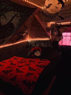 a bedroom decorated for halloween with lights and decorations on the walls, bedding and ceiling