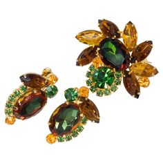 An exquisite brooch/pin and a pair of clip-on earrings by Juliana DeLizza & Elster. A single watermelon crystal is prong set and accented with smaller chatons and navettes in amber, green, yellow, and orange colors. Pin: 4.3cm x 3.9cm Earrings: 3.3cm x 1.9cm Glamorous Jewelry, A Group Of People, Group Of People, Crystal Brooch, New Leaf, Melon, Clip On, Prong Setting, Orange Color