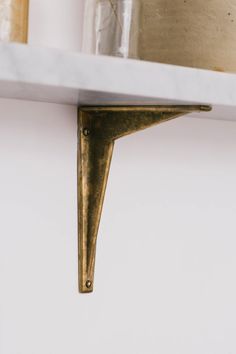 a white shelf with some gold items on it