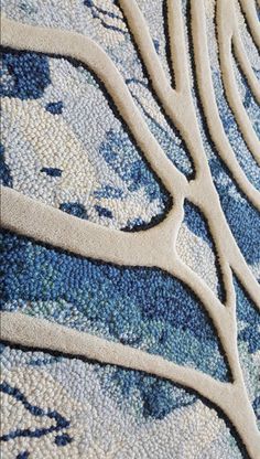 closeup of an intricate blue and white design on a rug with wavy lines in the middle