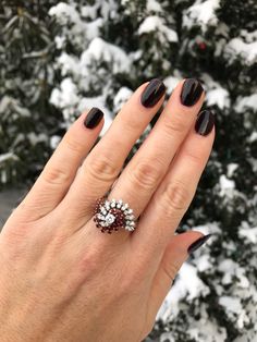 Dramatic swirls of synthetic rubies and diamonds accent this 1970s cocktail ring. A fabulous 18k white gold ring is adorned with 22 faceted synthetic rubies and 23 round brilliant diamonds. The top of the ring measures 0.7 inches from top to bottom by 0.85 inches wide. The interior of the band is marked for 18k gold. The center diamond measures 0.20 carat with G-H color, SI3 clarity, and there are 22 side diamonds. The total carat weight of all diamonds is 0.86ct. The ring is currently a size 7 Elegant Ruby Ring With Diamond For Party, Fine Jewelry Ruby Ring With Diamond For Party, Party Fine Jewelry Ruby Ring With Diamond, Ruby Rings For Party, Fine Jewelry Style, Formal Multi-stone Ruby Ring In Cubic Zirconia, Formal Multi-stone Ruby Ring With Cubic Zirconia, Ruby Ring Vintage, Rubies And Diamonds, Diamond Ring Vintage