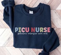 a sweater with the words nicu nurse on it sitting on top of a wooden floor