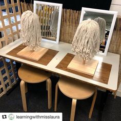 three wooden stools sitting on top of a table with two mirrors and mop heads