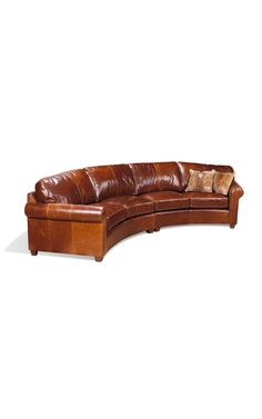 a brown leather sectional sofa with pillows on it