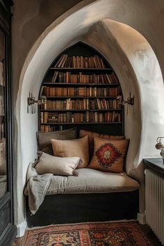 a room with a couch, bookshelf and rugs on the floor in front of it