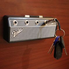 a guitar amplifier with keys hanging from it's back end and attached to the wall