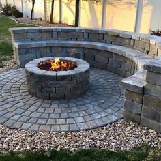 an outdoor fire pit surrounded by rocks and gravel