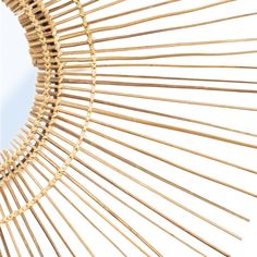 a circular mirror made out of bamboo sticks