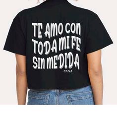 Maná womens cropped t-shirt Black Labios compartidos lyrics song quote. Te amo con toda mi fe, sin medida.  Very soft comfortable and lightweight cropped shirt. Please see size chart for measurements. Size up one size for a more loose fit. Quote printed on the back of the shirt. Front has small left chest MANA logo. Black Graphic Tee Cropped Shirt With Text Print, Black Punk T-shirt For Concert, Black Slogan Band Merch Tops, Black Band Merch T-shirt For Festival, Black Band Merch Shirt With Text Print, Mana Concert, Lyrics Song, Cropped Shirt, Cropped T Shirt