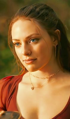 a beautiful young woman in a red dress posing for the camera with her hand on her hip