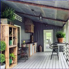 a porch with chairs, table and potted plants