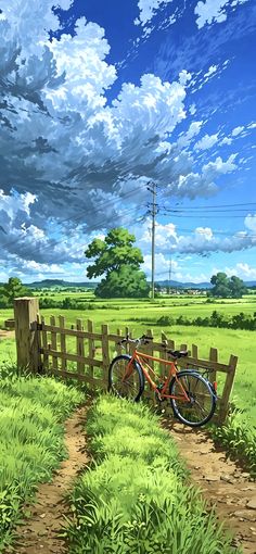 a bike parked next to a wooden fence in the middle of a green field under a cloudy blue sky