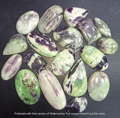 several green and white rocks on a black surface with the words, produced with intention of watermarks, written below them