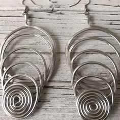 Hand crafted and hammered to form these beautiful wire swirl earrings. Perfect for any outfit. Accessories are life! Deets- Hand formed and hammered Aluminum wire Colors: Silver or Copper Length: Approximately 3 inches Super lightweight Listing is for one pair of earrings in either silver or copper. Wire Wrapped Metal Hoop Earrings, Silver Bohemian Wire Earrings, Bohemian Silver Wire Earrings, Elegant Swirl Ear Wire Earrings, Wire Wrapped Swirl Earrings, Spiral Wire Wrapped Metal Hoop Earrings, Metal Swirl Earrings With Ear Wire, Hand Forged Spiral Metal Earrings, Handmade Swirl Metal Earrings