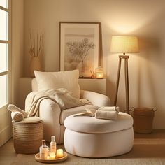 a living room with a round ottoman and candles on the side table next to it