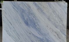 a large marble slab with blue and white streaks on it's surface in a warehouse