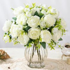 a vase filled with white flowers on top of a table