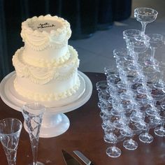 there is a wedding cake and wine glasses on the table