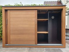 an outdoor storage area with wooden doors and shelves