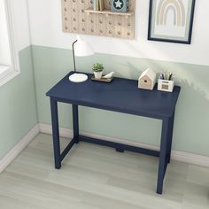 a blue desk with a lamp and pictures on the wall