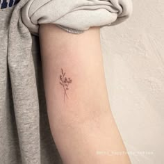 a small flower tattoo on the arm