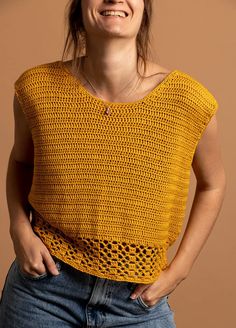 a woman is smiling and wearing a yellow knitted top with holes in the front