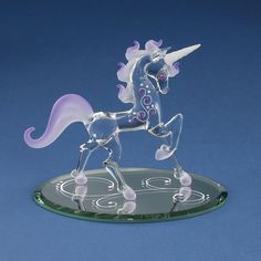 a glass figurine of a unicorn on top of a circular base with circles around it