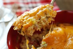 a close up of a spoonful of food on a plate with utensils