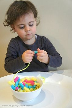 a young child sitting at a table with a bowl of cereal in front of her