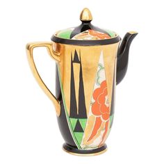 a black and gold teapot with an orange flower painted on the front, sitting against a white background