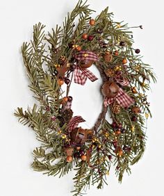 a christmas wreath with pine cones, berries and bells