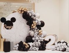 a table topped with balloons and mickey mouse decorations