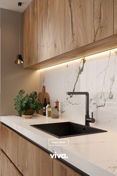 a kitchen with white marble counter tops and wooden cabinetry, along with black faucet lights